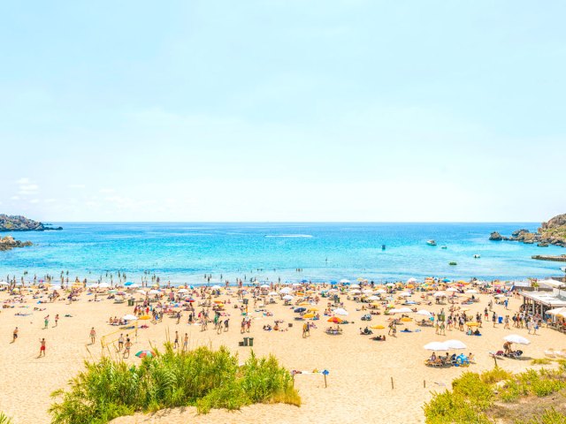 Crowded beach under sunny skies in Malta