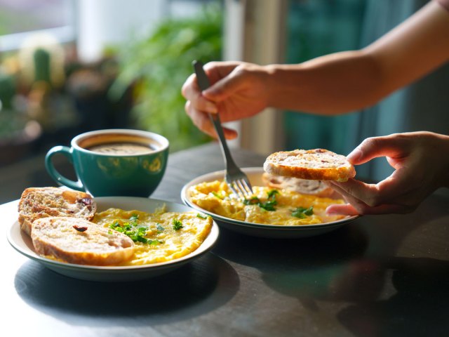 Person eating omelette and toast