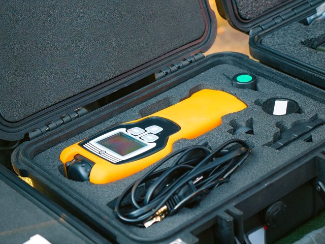 A yellow radiation-measuring device in its box