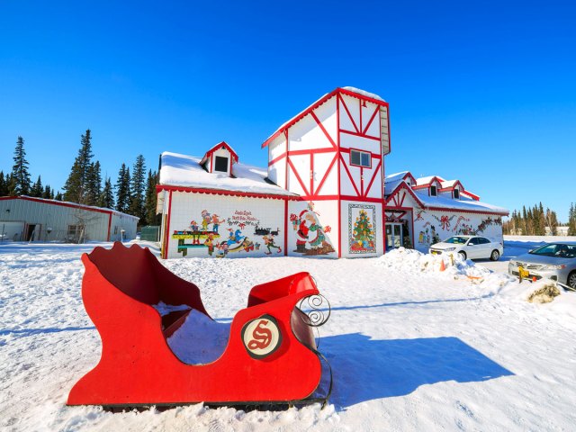 Santa Claus-themed building and sled seen on snowy day in North Pole, Alaska