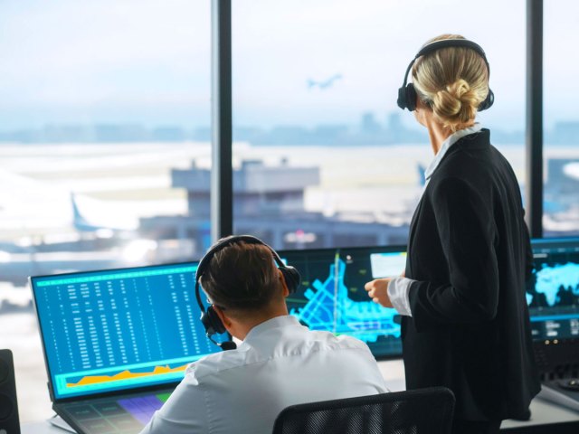 Air traffic controllers viewing airfield from control tower