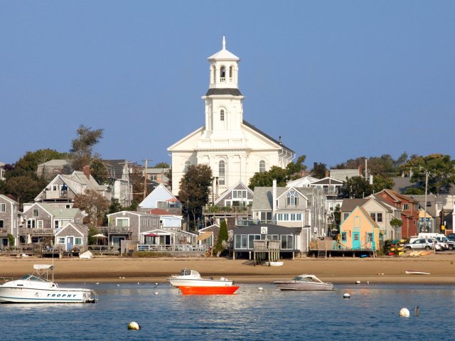 Church towering over waterfront buildings and boats in Provincetown, Massachusetts