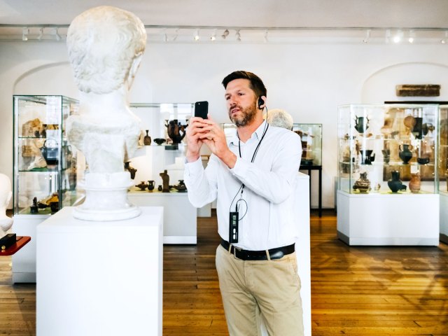 Museum goer taking photograph of sculpture