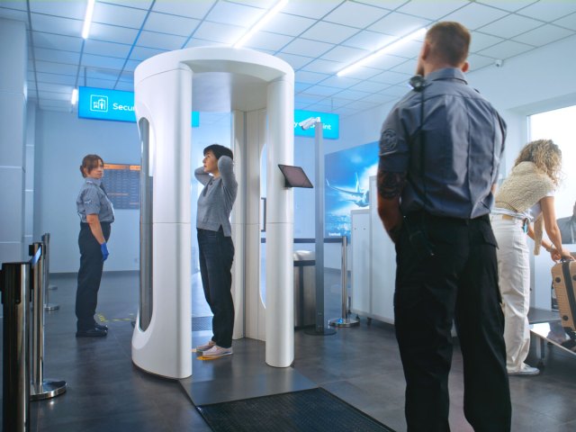 Traveler in body scanner at airport security checkpoint