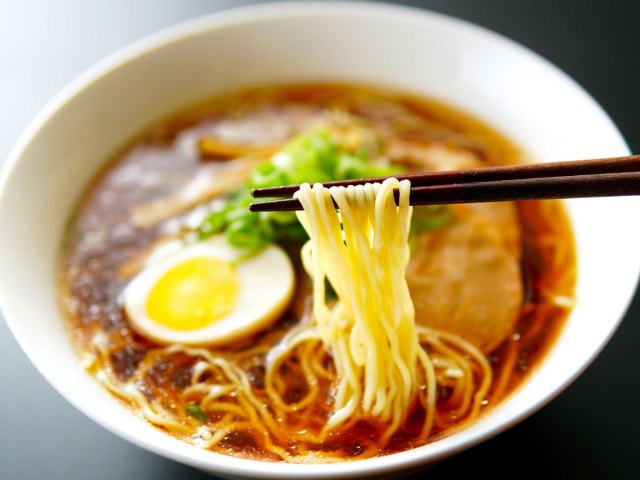Person eating ramen with chopsticks