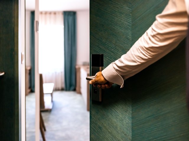 Guest opening hotel room door