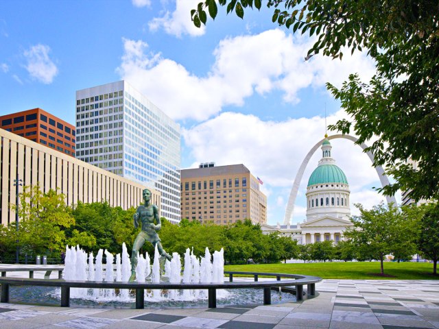 Statue in fountain with Gateway Arch and St. Louis skyline in background