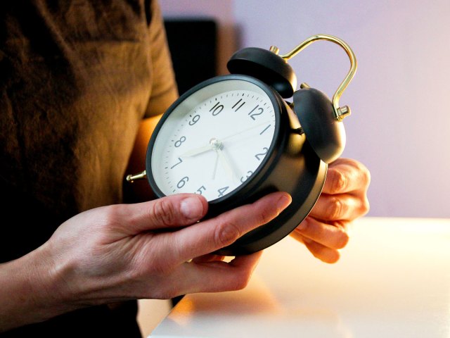 Person holding alarm clock