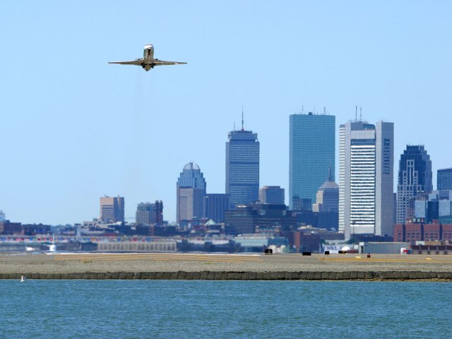Plane taking off from Logan Airport with Boston skyline in background