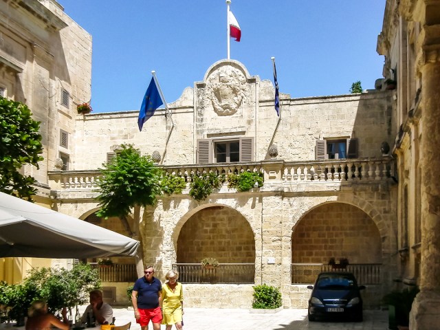 People walking in front of Xara Palace in Mdina, Malta