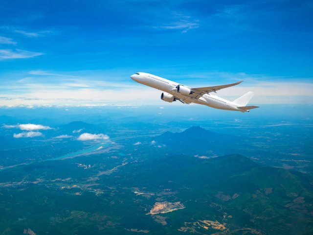 Airplane ascending over mountains