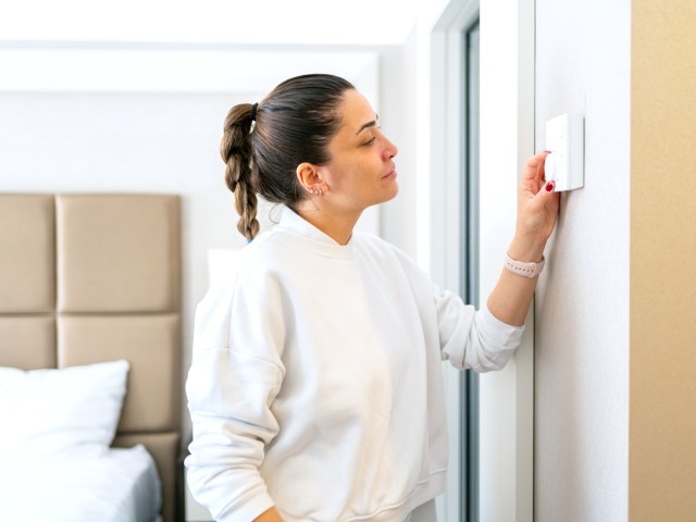 Hotel guest adjusting thermostat