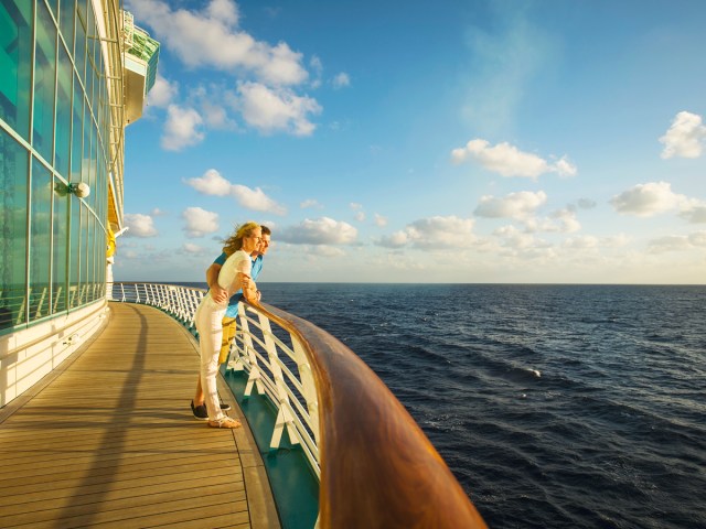 Couple looking out to sea from cruise ship balcony