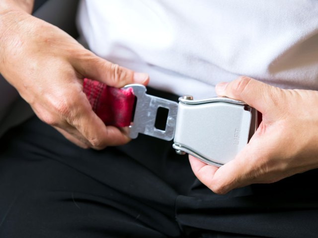 Airplane passenger fastening seatbelt