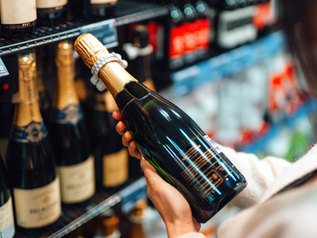 Person looking at bottle of bubbly at store