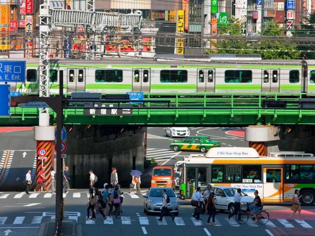 Train crossing over busy street in Tokyo, Japan