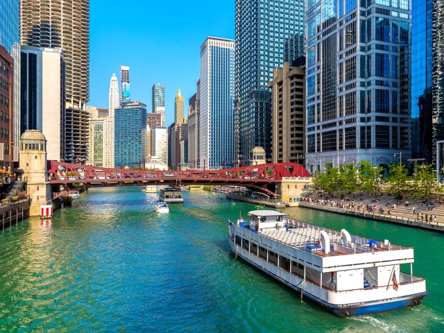 Tour boat cruising on Chicago River past skyscrapers